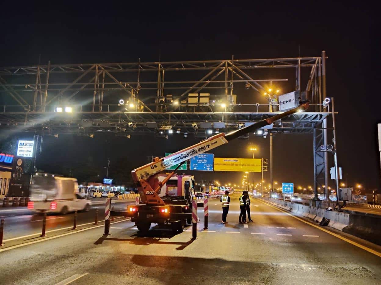 รถกระเช้าติดรถบรรทุก PST.Crane กำลังปฏิบัติงานซ่อมป้ายโฆษณาบนทางด่วน พร้อมกรวยจราจรและสัญญาณไฟฉุกเฉิน